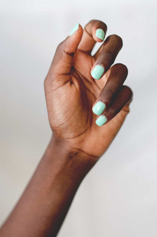 Pastel mint green nail polish hand swatch on dark skin tone by sienna