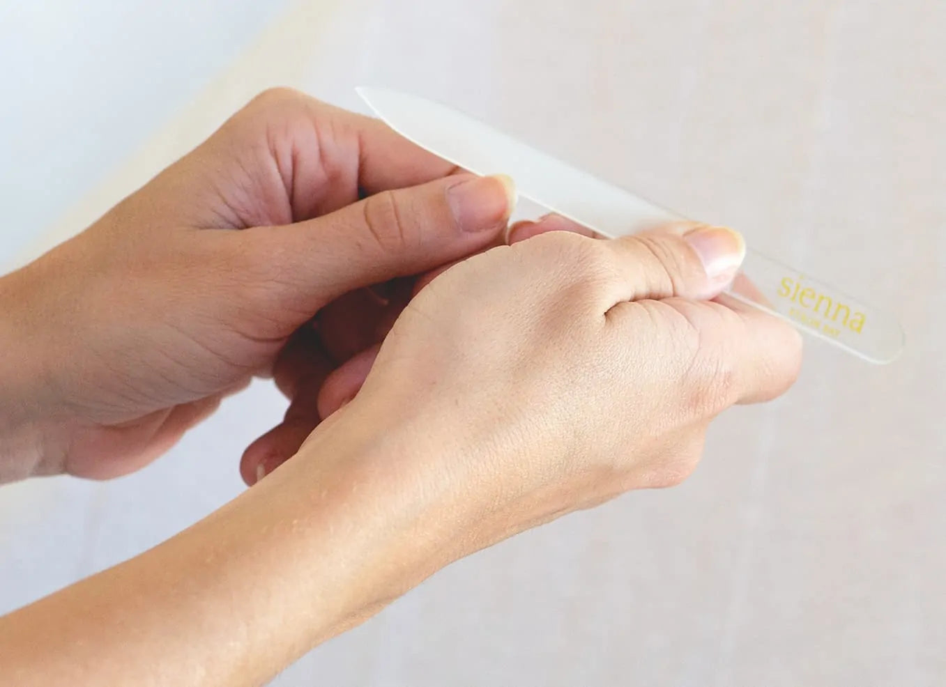 hands using glass nail file by sienna