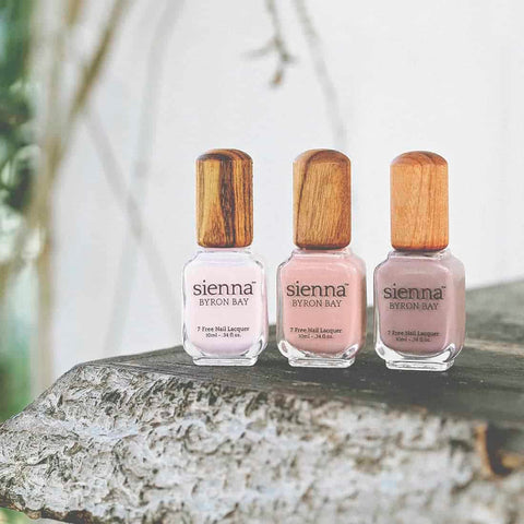 nude and pink nail polish glass bottles with timber cap by sienna on wooden shelf