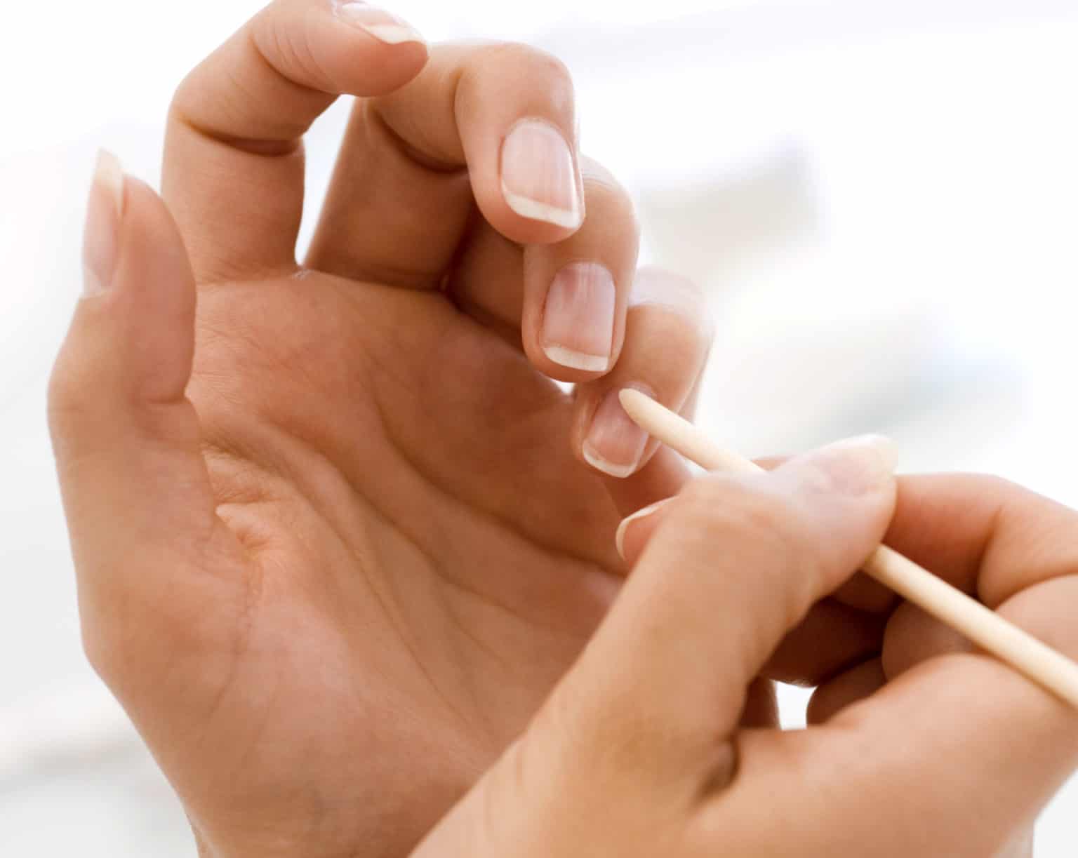 orange stich nails tool used on fair skin tone hands