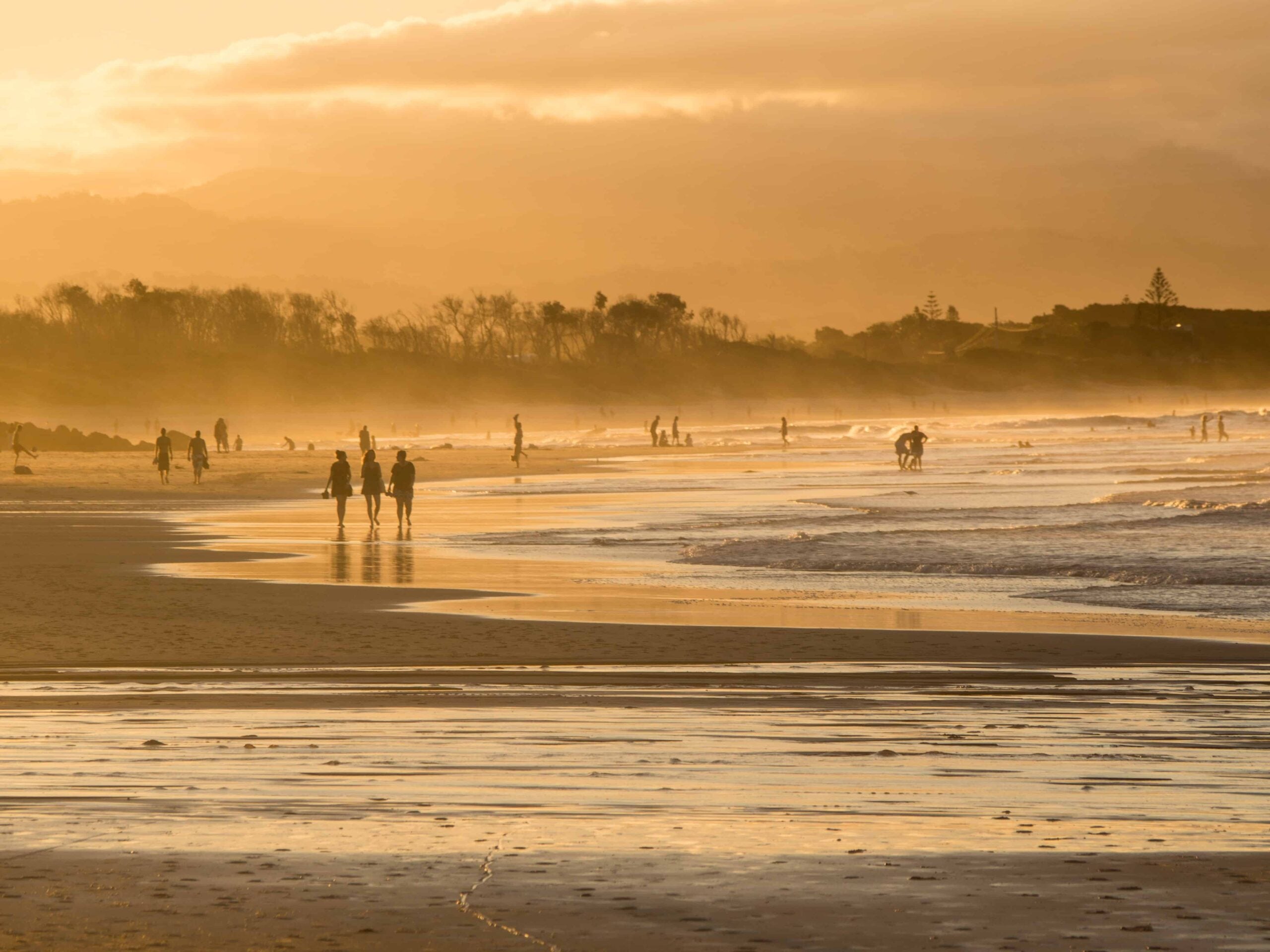 People walking in Sunset light on the beach in Byron Bay