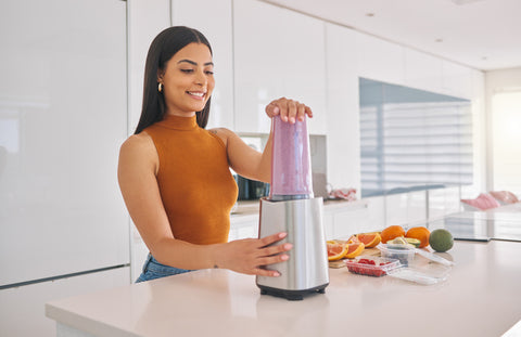 woman preparing a smoothie in the kitchen at home