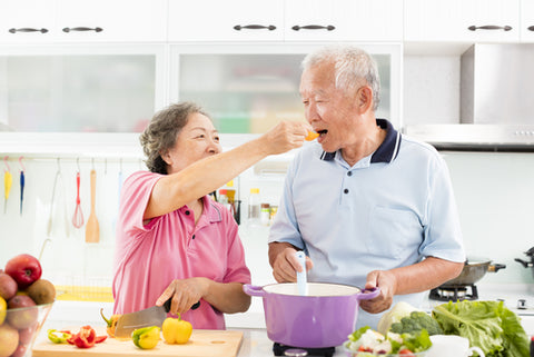 senior couple cooking in kitchen