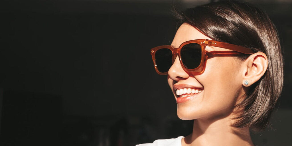 Gros plans sur les femmes souriantes qui portent des lunettes de soleil pliables