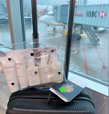 Oneiro Travel kit on a carryon with an airport backgrouns 