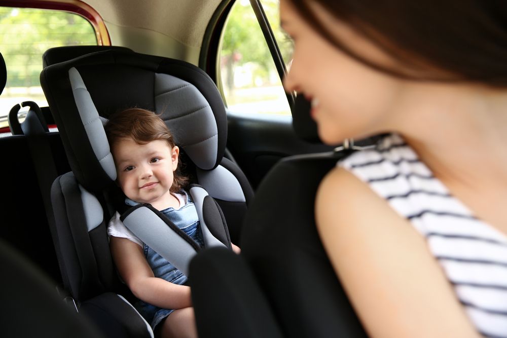 Mama sa mesta vozača se okrenula i gleda bebu koja je u auto sedištu