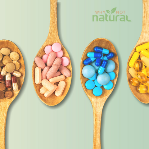 Multivitamin pills and tablets arranged in wooden spoons.