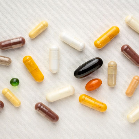 Various pills and capsules on a white surface.