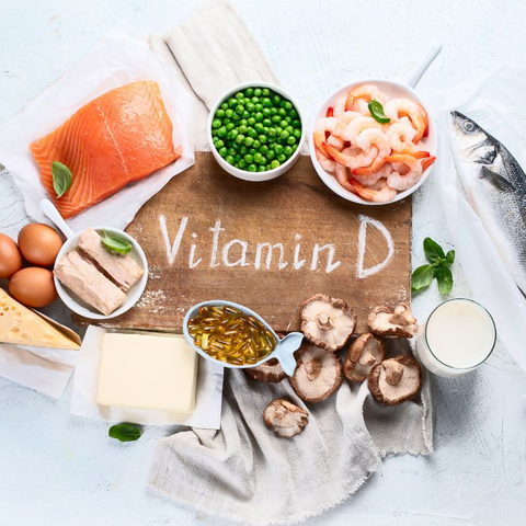 A table with a variety of foods, including fish, eggs, and mushrooms, that are rich in vitamin D.