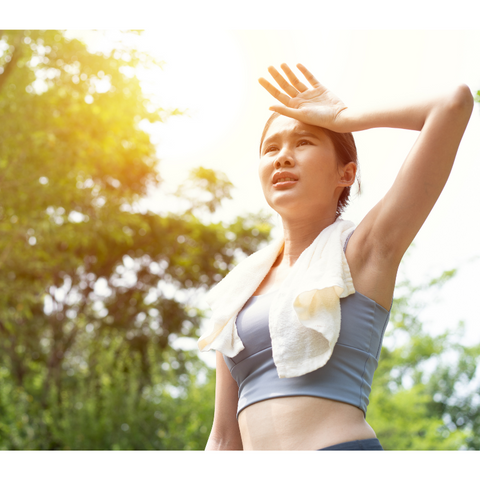 Image of a woman in the sun, hands on head, showing signs of dehydration.