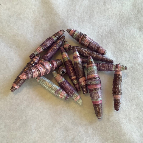 handmade tyvek beads in a pile on white fabric