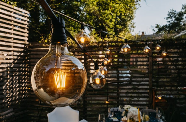 A close up on an outdoor ambient light hanging over a patio