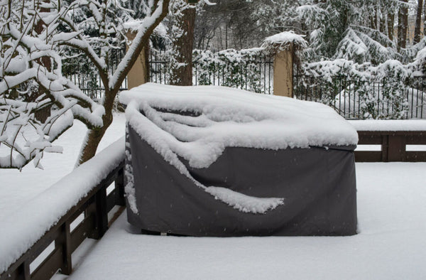 Patio furniture cover protecting outdoor furniture from snow.