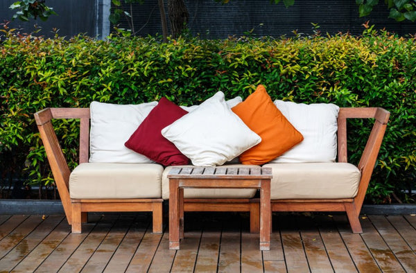 A stack of three outdoor cushions on patio furniture