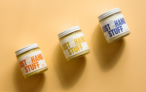 Three 100g Jars of Just Hand Stuff All Natural Hand Balms in a Flat Lay Photo