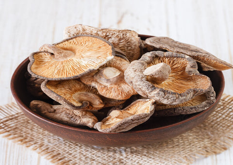 A dried magic mushroom in a wooden bowl