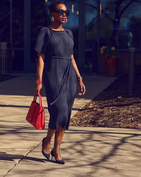 Farotelle wearing Ann Taylor's belted plissé blue midi dress with M.Gemi blue suede pumps and red bag as Spring Summer Office Workwear Dress Outfit Color-Blocked Style.