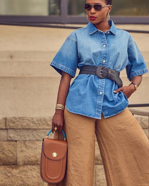 Style influencer Farotelle wearing Banana Republic khaki wide-leg linen pants with a belted denim shirt. She is holding a brown handbag and wearing sunglasses.