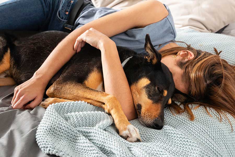 woman sleeping with black dog