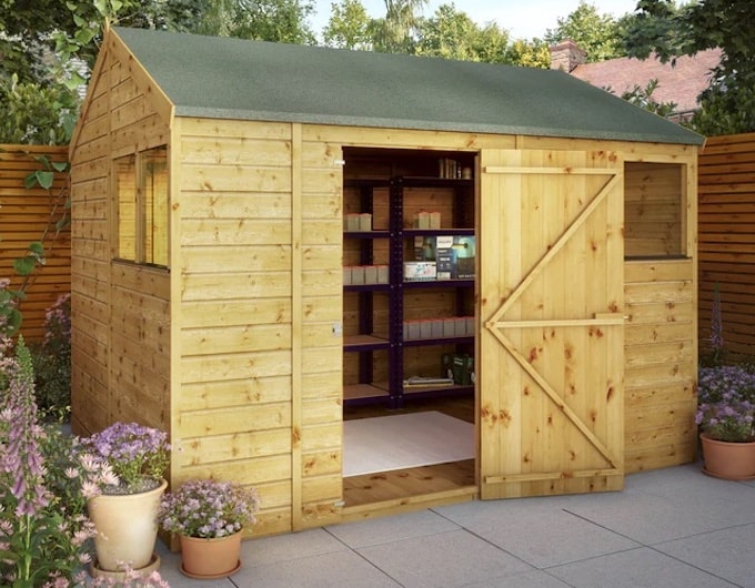 Medium sized shed with door open showing workshop
