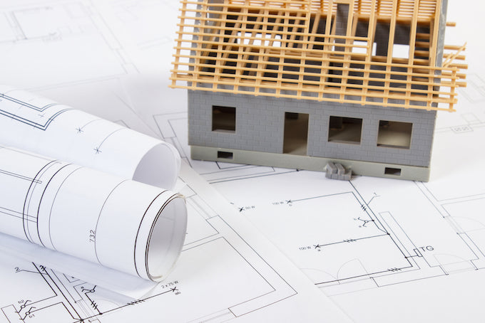 Blueprints of house build with mini model of a house