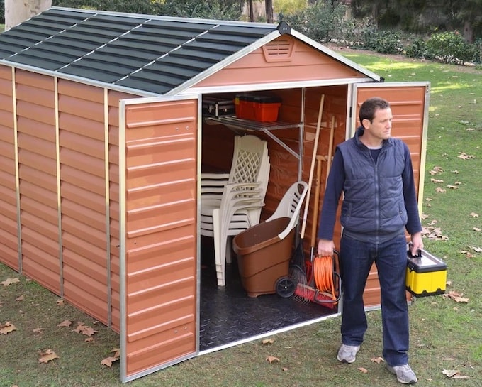 Amber coloured plastic shed with double doors open showing garden furniture