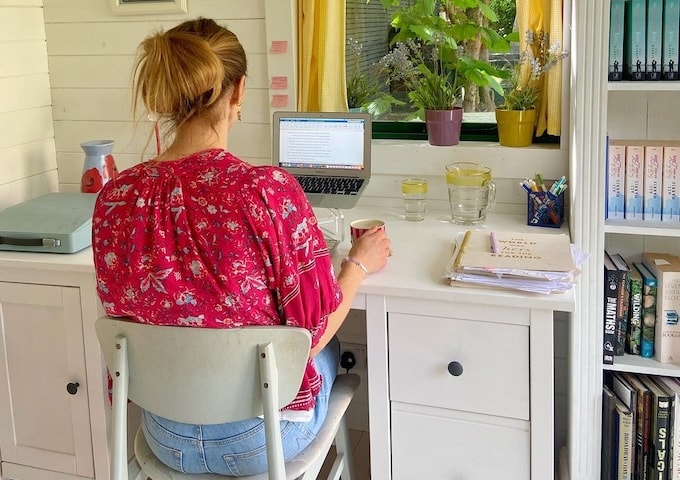 Author sitting inside writing shed