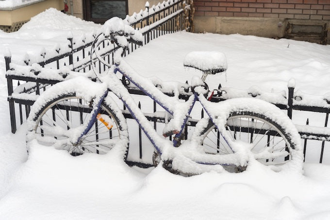 Bicycle covered in snow outside