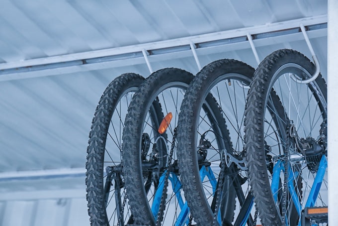 Group of bikes being stored vertically in metal shed