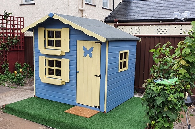 Blue and yellow playhouse with butterfly decoration