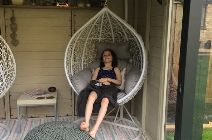 Person sitting in egg chair in summerhouse
