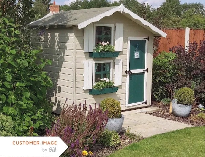 Cream and white playhouse with green door