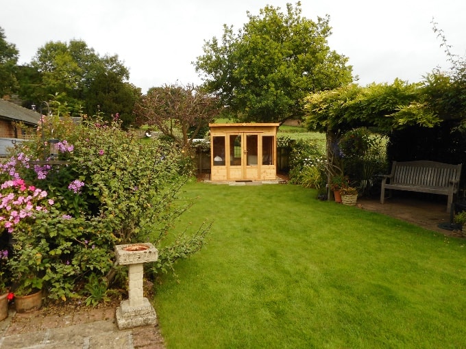 Waltons wooden summer house in a garden 