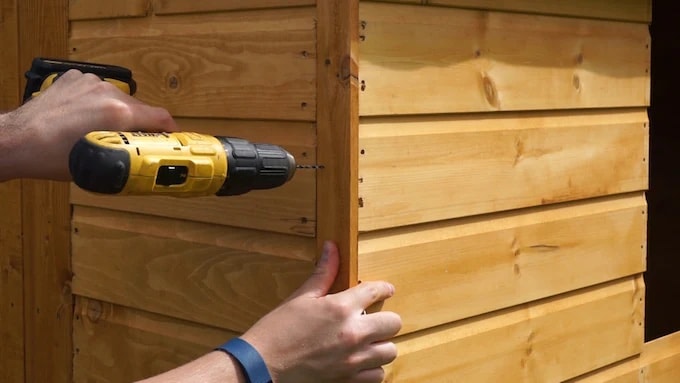 Installing corner trims on shed