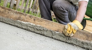 A wooden plank being used to even out concrete