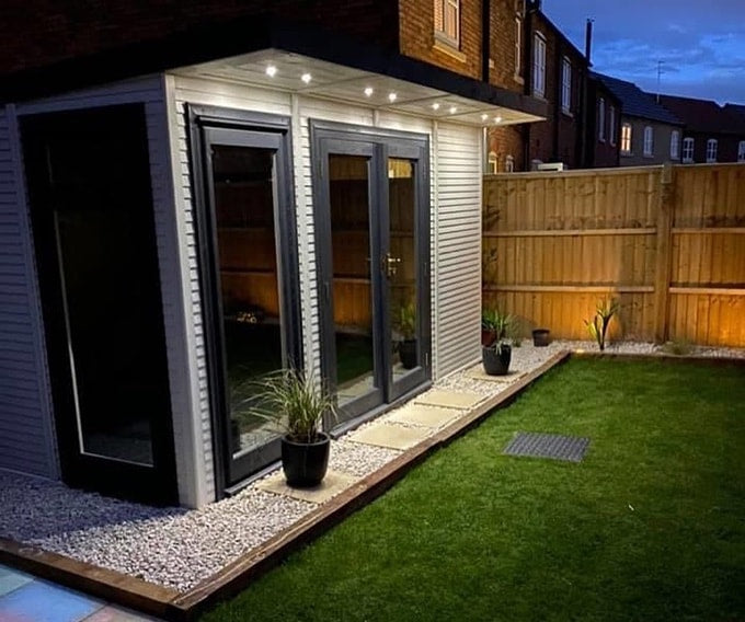 Nighttime image of Waltons Insulated Garden Room with exterior lights
