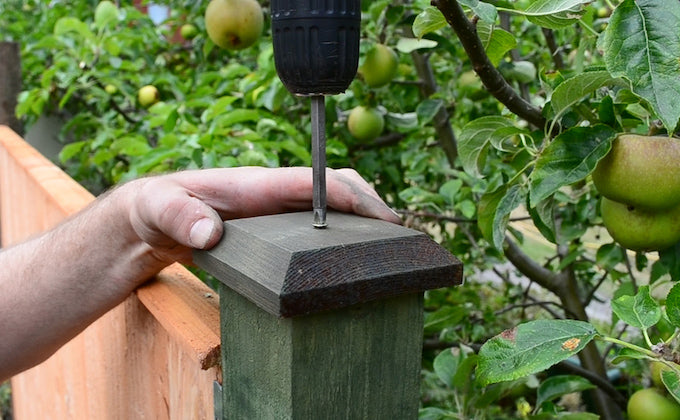 postcaps on a fence being screwed in