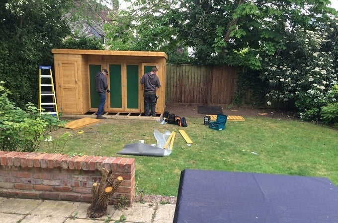 Construction crew finishing building Waltons summerhouse in garden