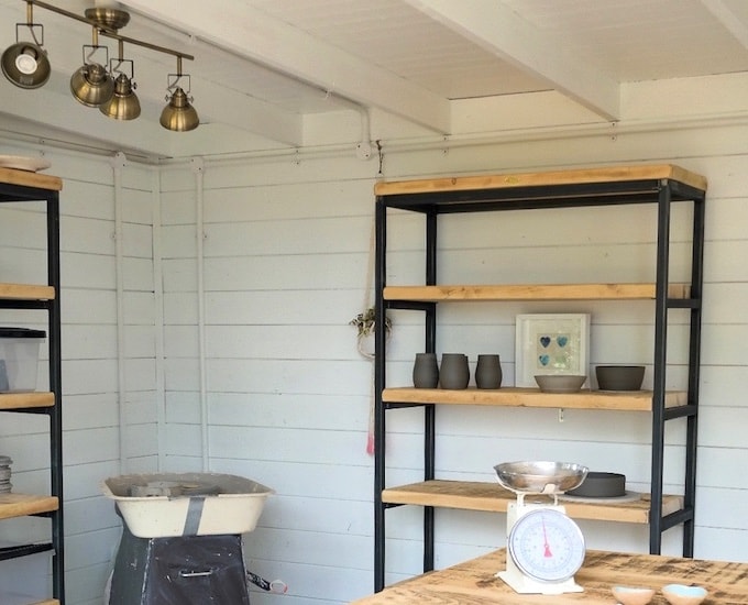 Overview of pottery studio inside log cabin 
