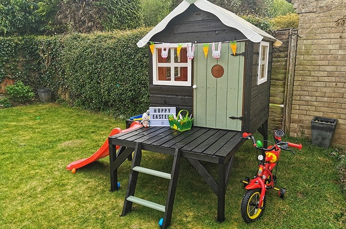 Painted green playhouse with slide and Easter decorations