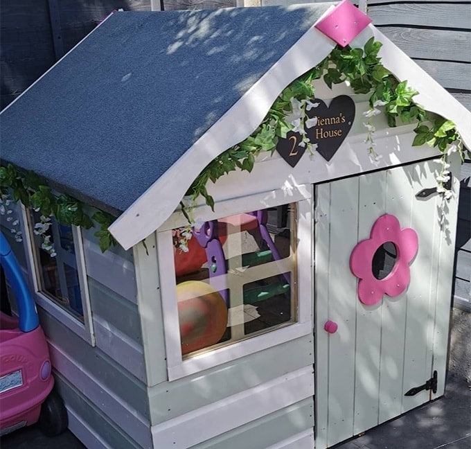Blue, white and pink playhouse with greenery