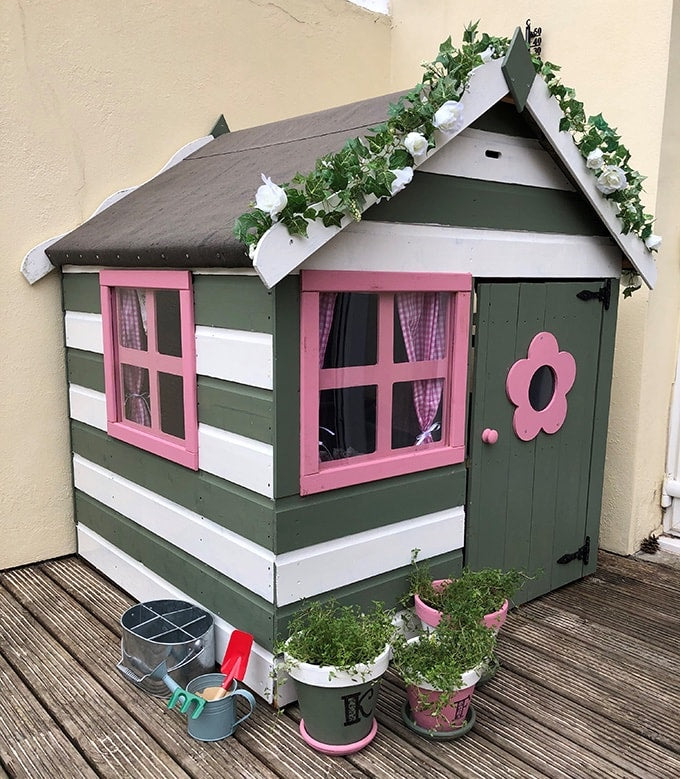 Green, white and pink playhouse with flowers