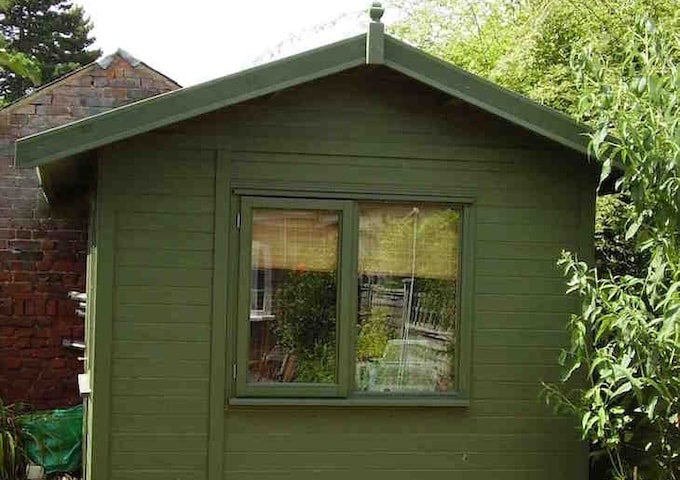 Green wooden shed in garden