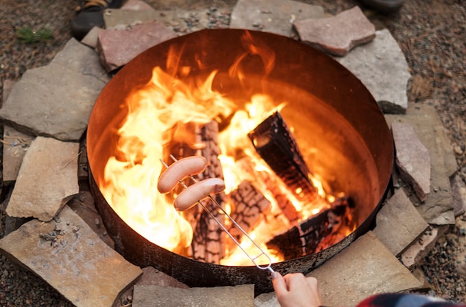 Cooking sausages over a firepit turned BBQ