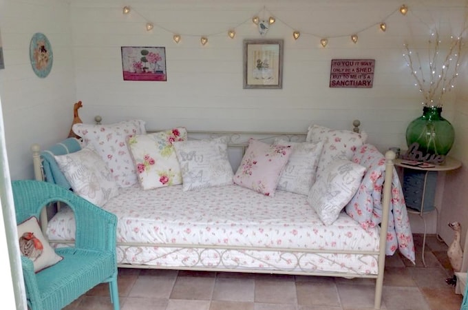 Interior of Waltons summerhouse with daybed and fairylights