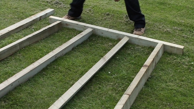 Man laying down timber on grass