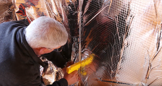 Person fitting insulation in a shed