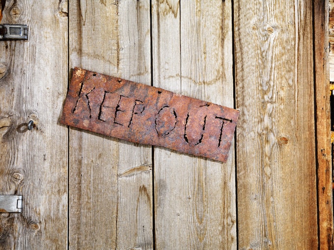 Metal sign saying 'Keep out' on wooden shed