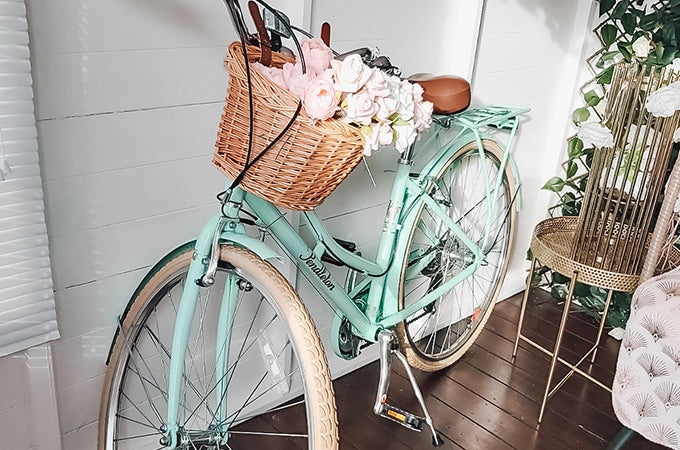 Mint green bicycle with flowers in basket