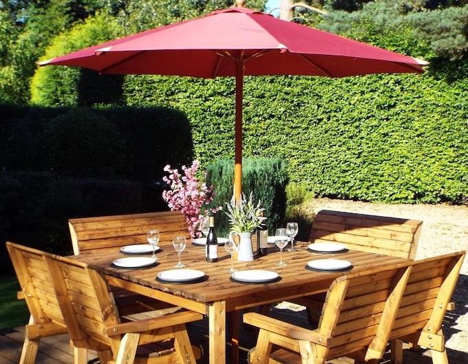 Six seater outdoor dining table with red parasol